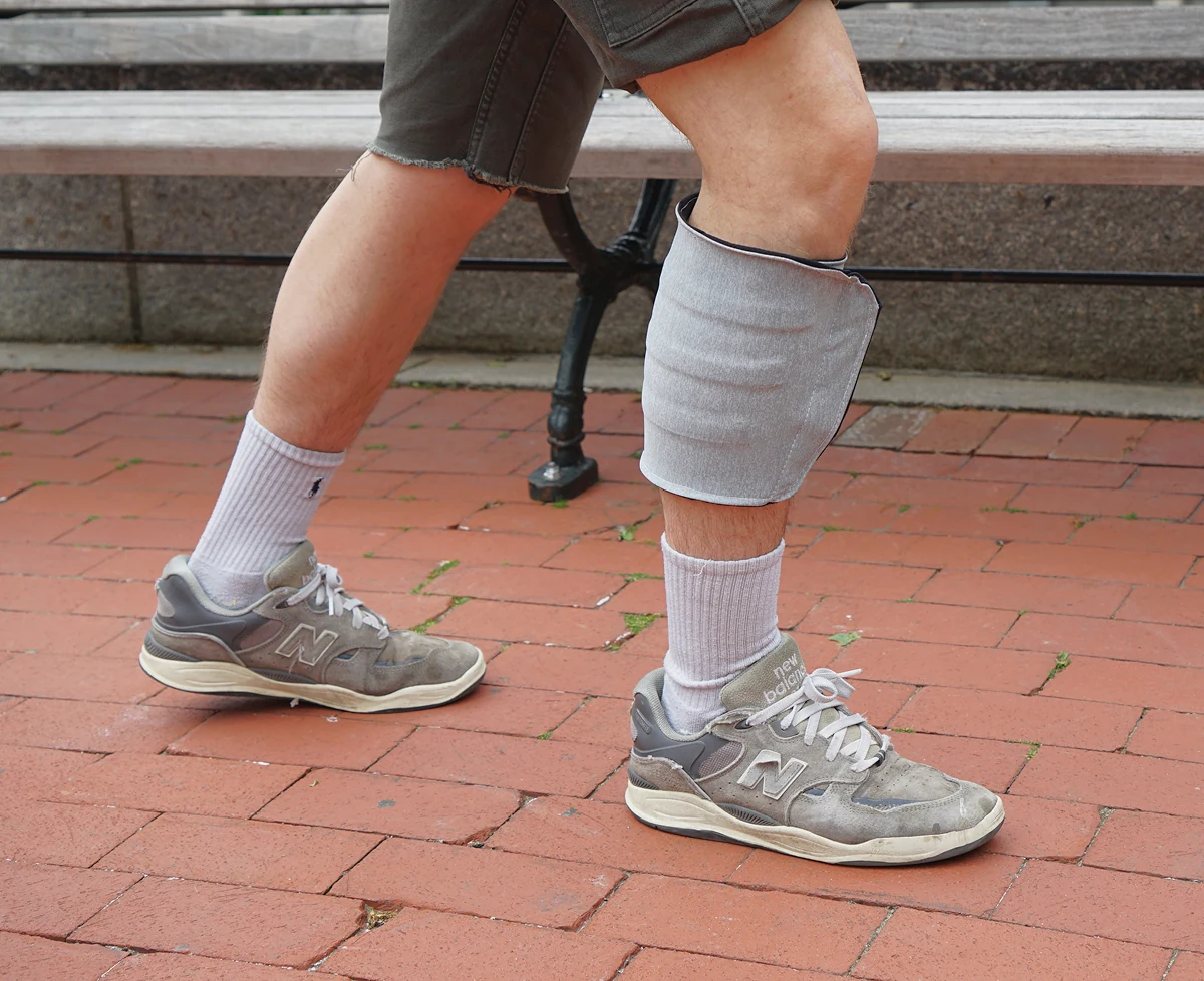 Working compression sleeve worn on the calf beside an outdoor bench